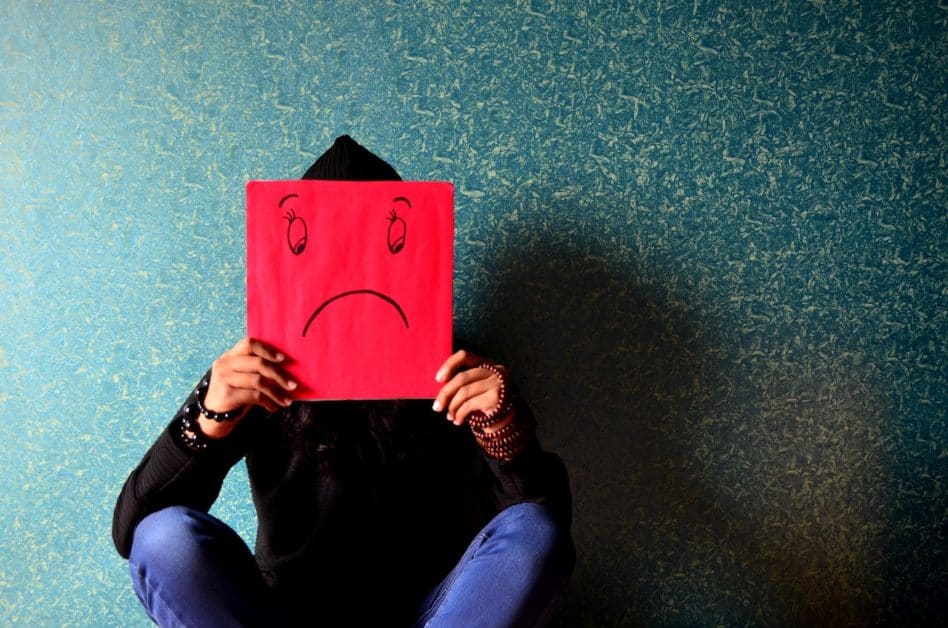 This man holding a picture of a sad face in front of his actual face perfectly captures the nature of depression. Don't suffer alone.