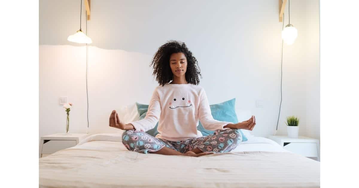 woman meditating in bed