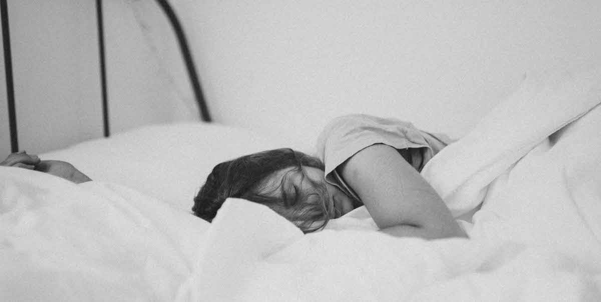 woman sleeping in white sheets