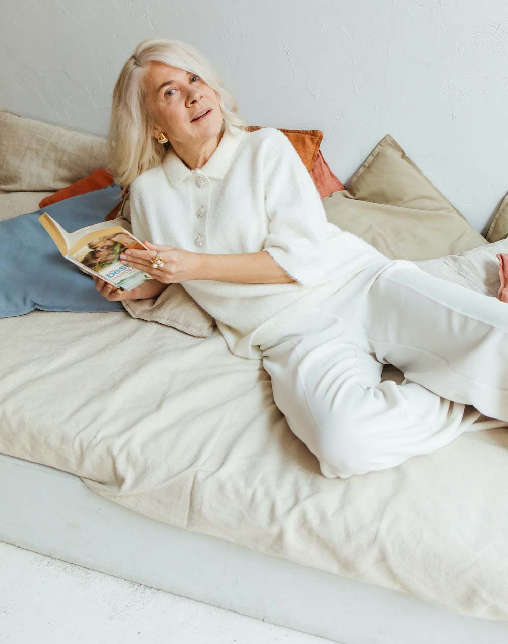 woman laying on bed with a book