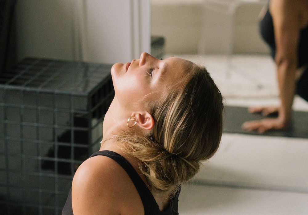 Woman in yoga class contemplating Thyroids and Irregular Periods
