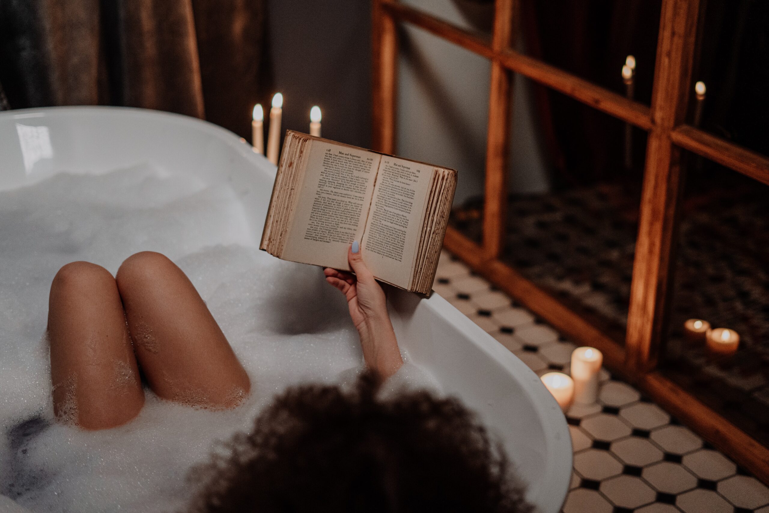 women reading book in a bath